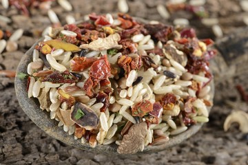 Brown rice, wild rice, Camargue red rice, green lentils, porcini mushrooms, peppers, tomatoes and parsley in a ladle