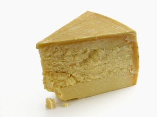 A wedge of parmesan on a white surface