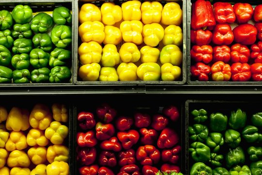 Green, yellow and red peppers for sale at farmers market