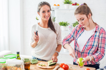 Women preparing dinner in a kitchen concept dieting healthy food