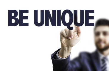Business man pointing the text: Be Unique