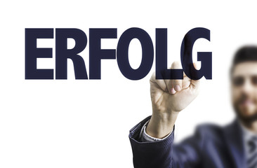 Business man pointing the text: Success (in German)