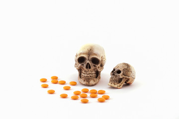 Human skull and drugs on isolated white background.