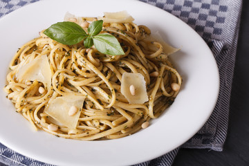 linguine pasta with pesto sauce, pine nuts and Parmesan cheese closeup
