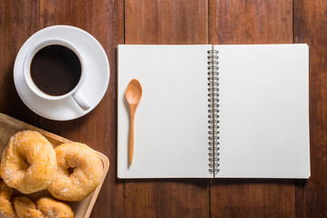 Recipe notebook, donuts, Coffee cup on wooden background, top vi