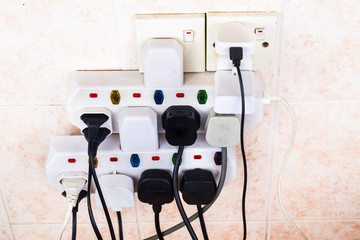 Multiple electricity plugs on adapter risk overloading and dangerous