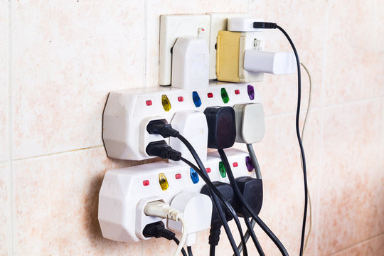 Multiple electricity plugs on adapter risk overloading and dangerous