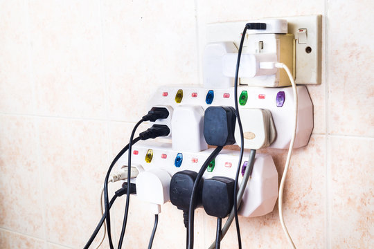Multiple electricity plugs on adapter risk overloading and dangerous