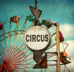 aged and worn vintage photo of circus sign with ferris wheel