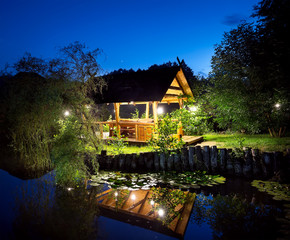Wooden gazebo lit lanterns on the lake
