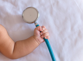 medical instruments stethoscope in hand of newborn baby girl