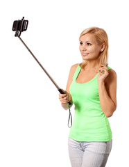 Young woman taking selfie photo with stick isolated on white