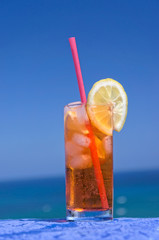 Cocktail drink in front of summer sea and sky background