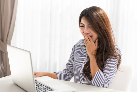 Beautiful young asian woman using laptop and is laughing, Beautiful happy girl looking at screen smiling sitting casual having fun on internet