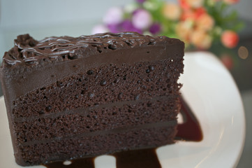 Piece of dark chocolate cake with blur flower