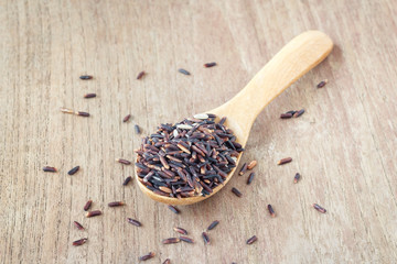 Rice berry, Brown rice in wooden spoon on wood, selective focus