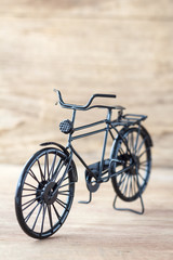Vintage model black bicycle on old wooden table.