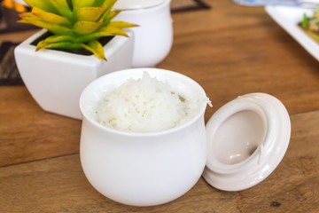 Steamed white rice in cup on wooden