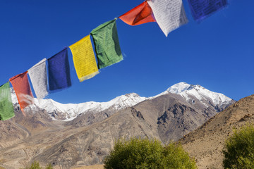 snow mountain range and tibetan prayer flags in the village ,Leh-Nubra Valley Road Ladakh ,India - September 2014