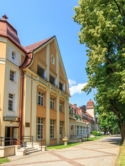 Fototapeta na wymiar Duszniki Zdrój - Budynek Sanatorium Jan Kazimierz oraz główna aleja spacerowa w Parku Zdrojowym