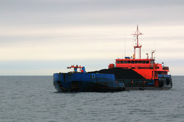 a barge loaded with coal at the roadstead of the island of Sakhalin