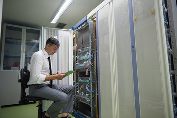 Naklejka na ściany i meble network engineer working in server room