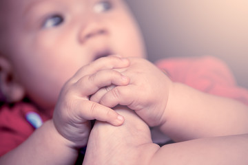 cute little boy hand hold own toe in soft color filter