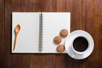Obraz na płótnie Canvas Recipe notebook, Coffee cup, cookie on wooden background, top vi