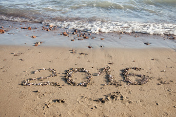 2016 written in sand on sunny beach