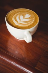 Cup of cappuccino with coffee art on the counter