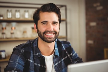 Obraz premium Portrait of a smiling man working on his laptop