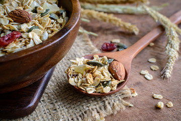 Oat and whole wheat grains flake in wooden bowl on wooden table