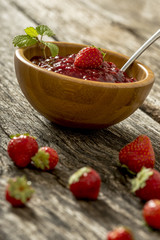 Fresh ripe strawberries and a bowl of jam