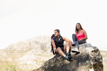 Young happy joggers sitting on rock