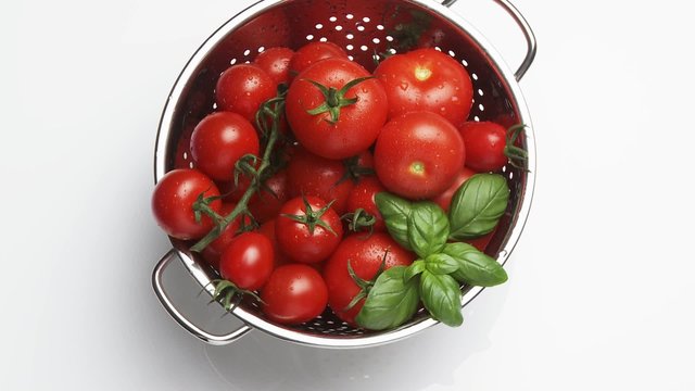 Tomatoes and basil leaves in a colander