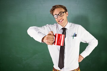 Composite image of young geeky businessman holding mug