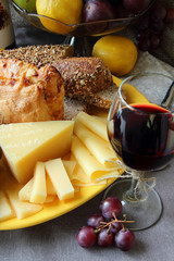 Grapes, a plate of cheese and a glass of wine..