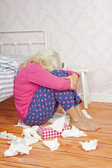 Sad woman sitting on floor against bed - 89518504