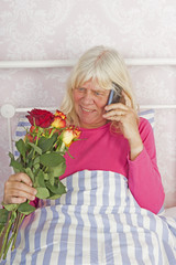 Woman in bed with roses and telephone - 89518536