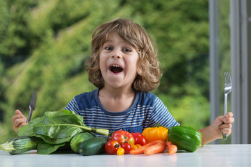 Cute little boy sitting at the table excited about vegetable meal, bad or good eating habits,...