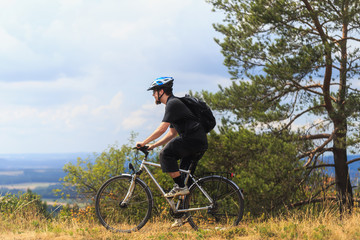 Obraz premium Biking in the Franconian Hills in Northern Bavaria. Young man on