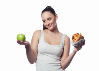 young girl deciding what to eat: an apple or hamburger