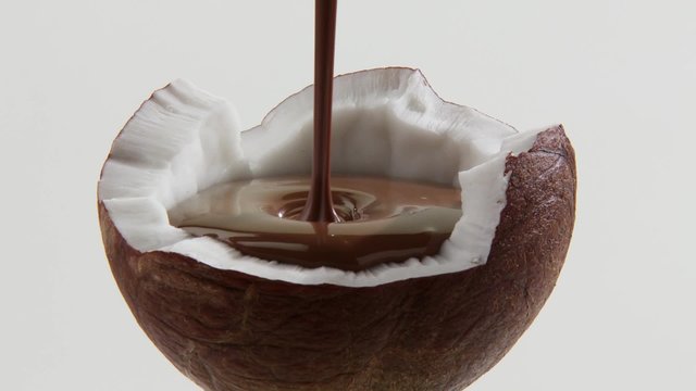 Filling half a coconut with chocolate sauce