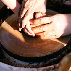 Hands working on pottery wheel