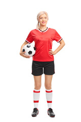 Young female football player holding a ball