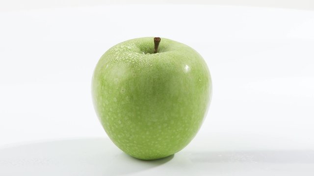 A rotating green apple