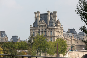 The Louvre and  the Seine River in Paris .  Louvre is one of the biggest Museum in the world, receiving more than 8 million visitors each year. Paris,France