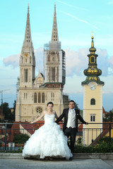 Obraz premium Bride and groom posing in front of church