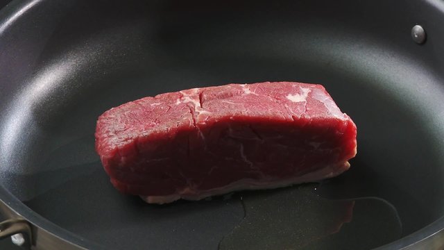 Frying beef sirloin in a frying pan