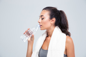 Fitness woman with towel drinking water